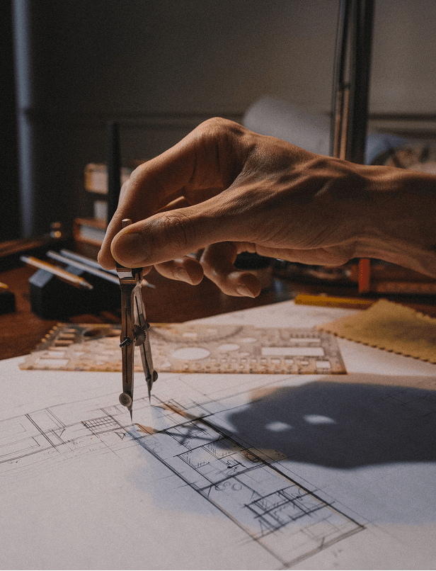 Arquiteto a analisar plantas de construção numa mesa de trabalho